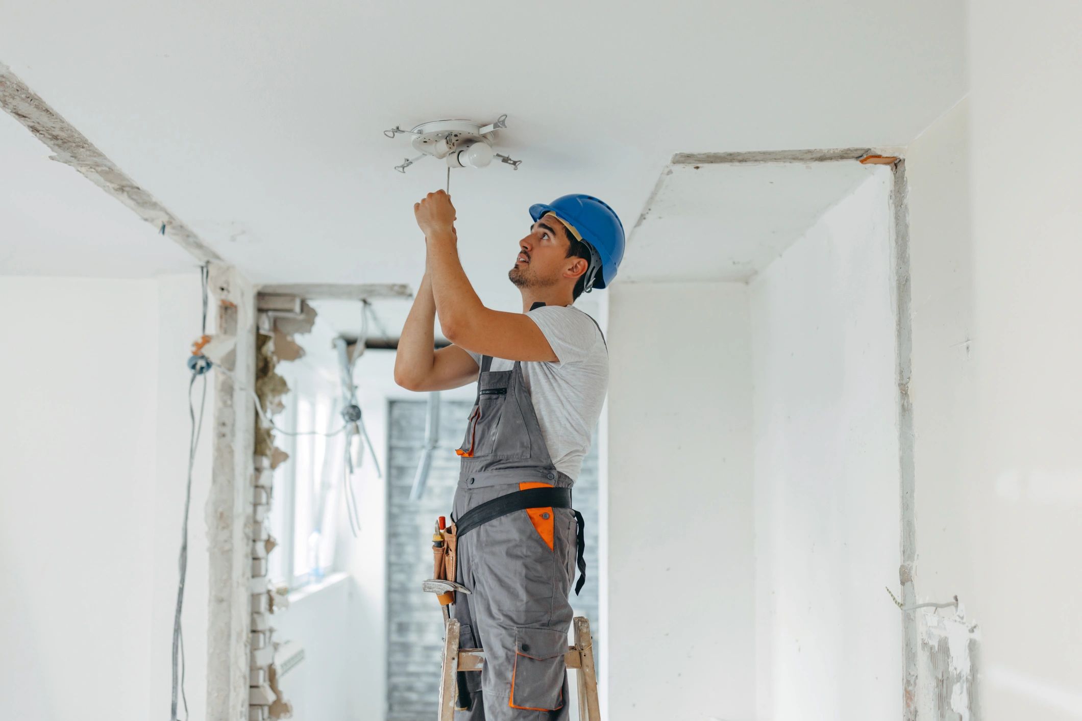 Electrician installing ceiling light