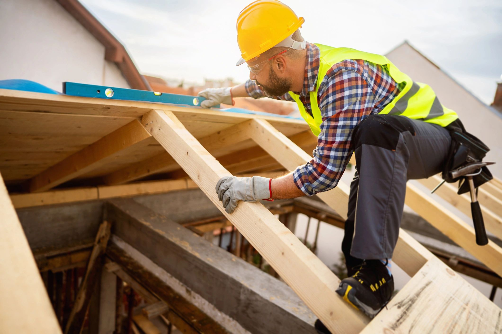Construction worker measuring roof framing